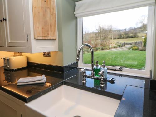 a kitchen counter with a sink and a window at Dale View Cottage in Bakewell