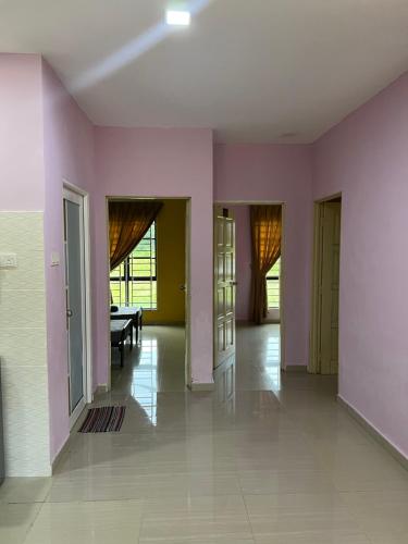um quarto vazio com paredes e portas cor-de-rosa em D` Totok HouseStay em Sepang