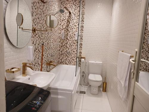 a bathroom with a sink and a toilet and a shower at Midtown Nile View Suites in Cairo