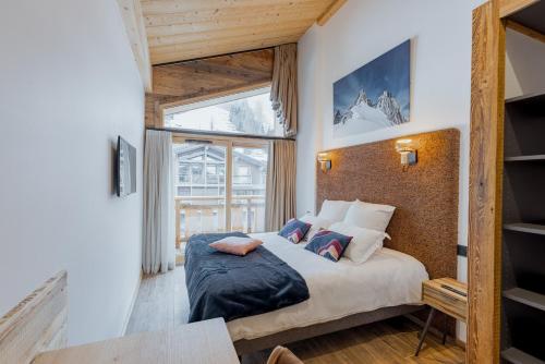 une chambre avec un lit et une grande fenêtre dans l'établissement Appartement Marianne - LES GETS, en plein centre et au pied des pistes, aux Gets