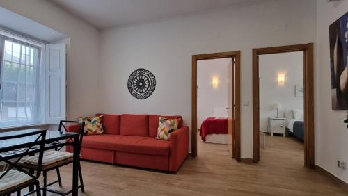 a living room with a red couch and a bedroom at Lightoasis Oeiras 3 in Oeiras