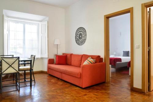 a living room with a red couch and a table at Lightoasis Oeiras 3 in Oeiras