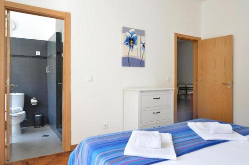 a bedroom with a bed and a bathroom with a shower at Lightoasis Oeiras 3 in Oeiras