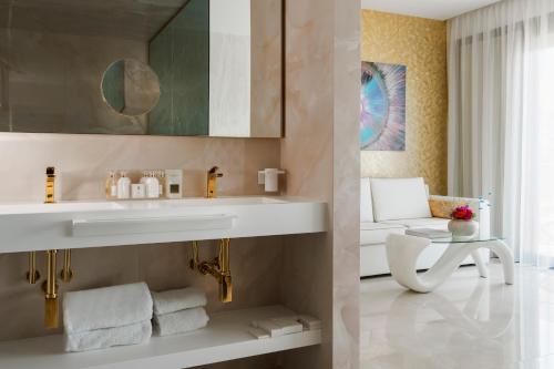 a bathroom with a white sink and a mirror at The Promenade Luxury Wellness Hotel in Riccione