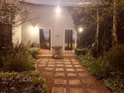 a stone walkway leading to a house at night at KarMichael Farm in Himeville