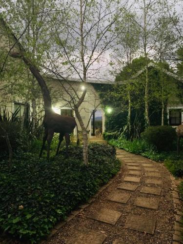 a statue of a horse standing next to a walkway at KarMichael Farm in Himeville