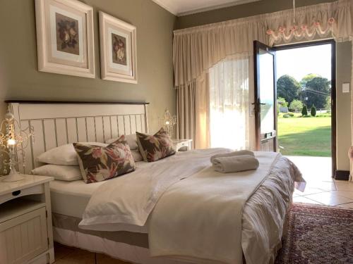 a bedroom with a large bed and a large window at KarMichael Farm in Himeville