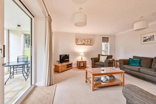 a living room with a couch and a table at Superb Sandbanks Apartment near Beach and Bars with Free Parking in Poole
