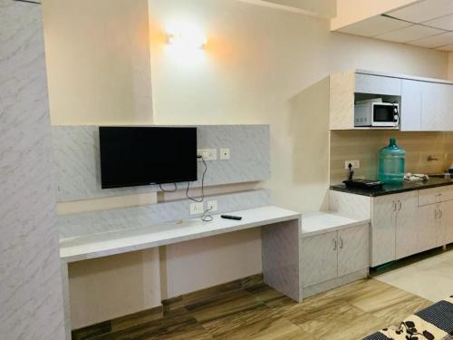 a kitchen with a counter with a tv on the wall at Hotel Moonlite in Greater Noida