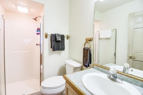 a white bathroom with a toilet and a sink at Lakefront Tofte Townhome with Deck and Views! in Tofte