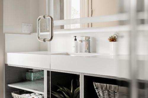 a white bathroom with a sink and a mirror at Gameday Oasis - Private Balcony - Jefferson Park - Tesoro in Denver