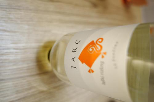 a bottle of wine with an orange logo on it at Farm Stay Jarc Vineyard in Svečina
