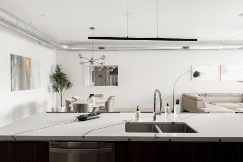 a white kitchen with a sink and a counter at Luxurious Escape - Walk to Empower Field - Tesoro in Denver