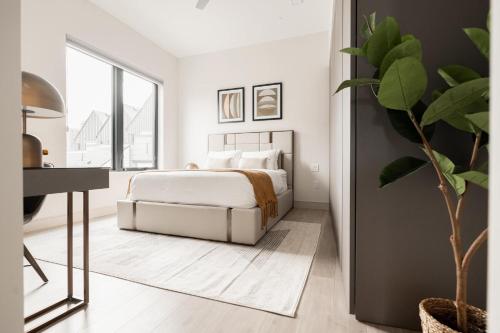 a white bedroom with a bed and a desk at City Views! - Chic Jefferson Park Condo - Tesoro in Denver