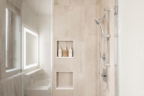 a bathroom with a shower with two bottles on a shelf at City Views! - Chic Jefferson Park Condo - Tesoro in Denver