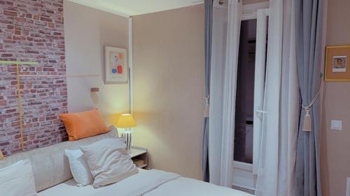 パリにあるCozy Paris Apartmentのレンガの壁、ベッド付きのベッドルーム1室