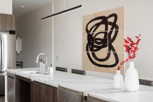 a kitchen with a sink and a counter with vases at Brand New Condo - Walk to Empower Stadium - Tesoro in Denver