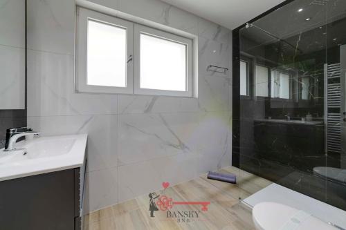 bagno con vasca, lavandino e doccia di Home Sofia Room 2 - Modern Station -By EasyLife Swiss a Lugano