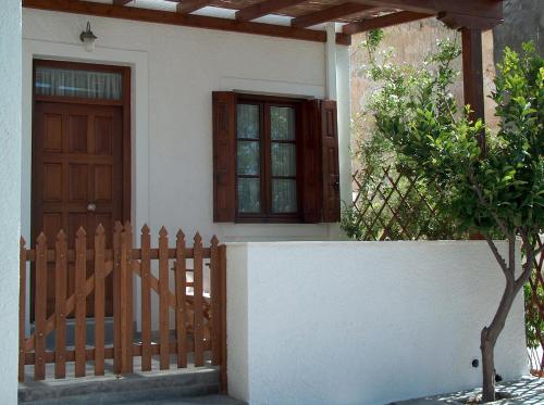 a house with a wooden door and a fence at Villa Notos in Adamantas