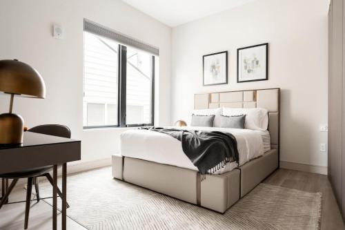 a white bedroom with a bed and a desk at Contemporary Condo - Grill - Balcony - Tesoro in Denver