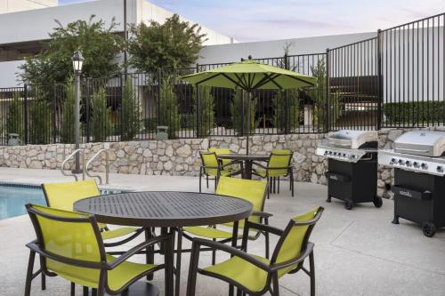 a patio with tables and chairs and a grill at SpringHill Suites Fort Worth University in Fort Worth