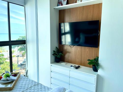 a bedroom with a flat screen tv on a wall at Beira-mar Boa Viagem - Costa Vicentina by Bnb Flex in Recife