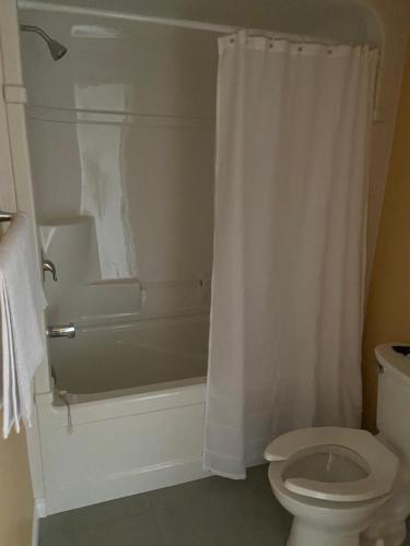 e bagno con servizi igienici, vasca e doccia. di Victoria Motel a Kitchener