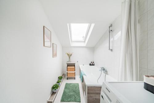 a white bathroom with a tub and a sink at City Lodge Vienna in Vienna