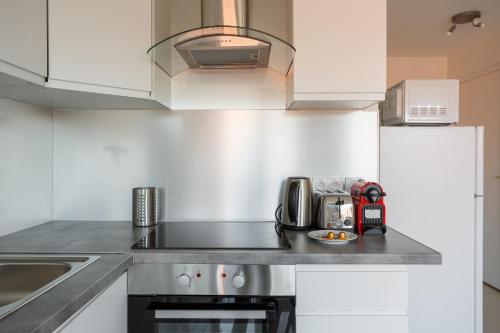a kitchen with white cabinets and a stove top oven at Le blanc mesnil bat A 2G in Le Blanc-Mesnil
