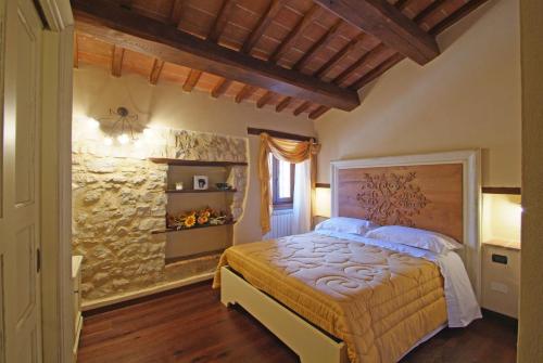 - une chambre avec un lit et un mur en pierre dans l'établissement Palazzo Del Papa Agriturismo, à Strettura