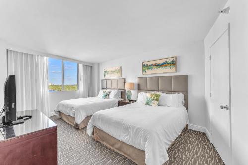 een hotelkamer met 2 bedden en een flatscreen-tv bij Eternal Sunrise Suite in Fort Lauderdale