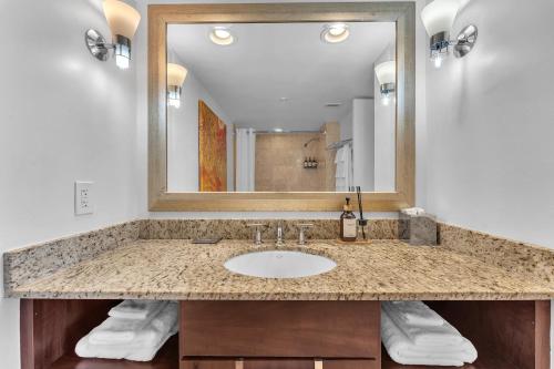 a bathroom with a sink and a large mirror at Eternal Sunrise Suite in Fort Lauderdale
