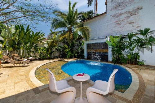 a swimming pool with chairs and a table and a fountain at Hotel Fundadores en Cauca Viejo Fundadores in Jericó