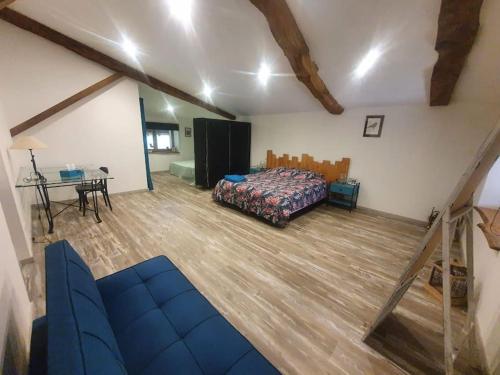 a bedroom with a bed and a table in a room at studio 2 spacieux 1à4 pers in Marboz