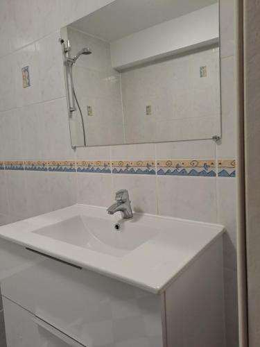un lavabo blanc dans une salle de bain avec un miroir dans l'établissement Appartement 3 pièces faubourg de Pierre, à Strasbourg