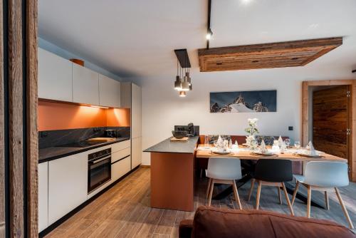 kuchnia ze stołem i krzesłami w pokoju w obiekcie Appartement Thom's - LES GETS, en plein centre et au pied des pistes w mieście Les Gets
