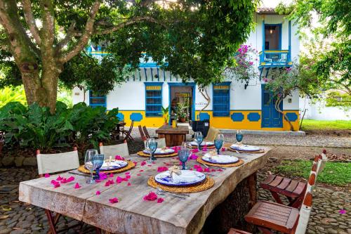 a wooden table with wine glasses and pink flowers on it at Hotel Fundadores en Cauca Viejo Fundadores in Jericó
