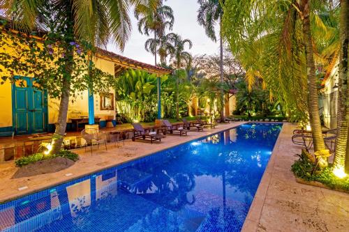 an image of a swimming pool in a resort with palm trees at Hotel Fundadores en Cauca Viejo Fundadores in Jericó