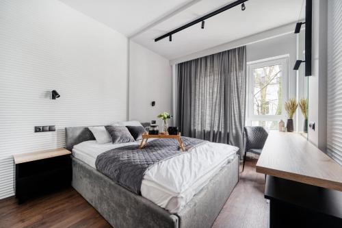 Un dormitorio con una cama con una mesa. en Łódź Prestige Suites - 55m2, Parking - by Rentujemy, en Łódź