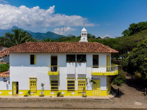 a building with yellow windows and a white tower at Hotel Fundadores en Cauca Viejo Fundadores in Jericó