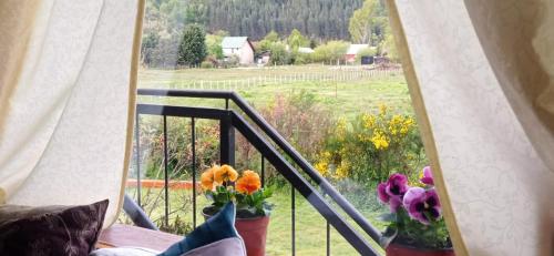 a balcony with a window with flowers on it at Departamento Campanita in San Martín de los Andes