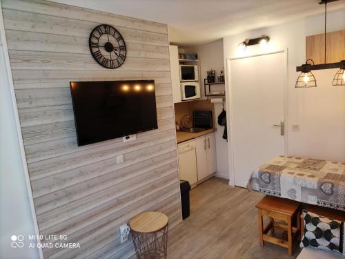 sala de estar con TV de pantalla plana en la pared en RISOUL Altaïr Jolie T2 confortable skis aux pieds, en Risoul