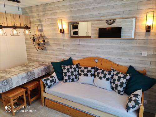 un divano con cuscini in una stanza di RISOUL Altaïr Jolie T2 confortable skis aux pieds a Risoul