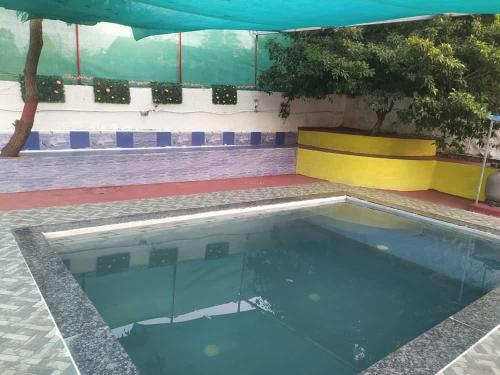 an empty swimming pool with a yellow and blue at Kimaya farm house in Panvel