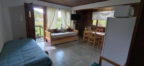 a bedroom with a bed and a room with a table at Departamento Campanita in San Martín de los Andes