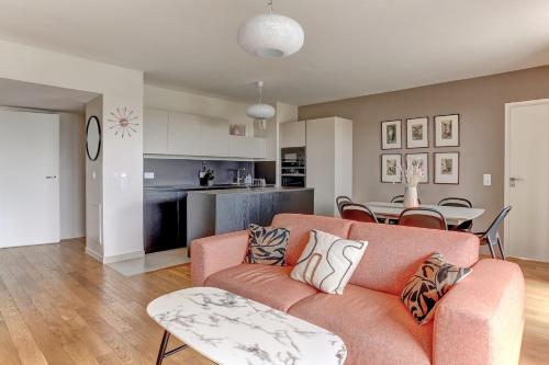 - un salon avec un canapé orange et une table dans l'établissement Le tocqueville - Versailles, à Versailles