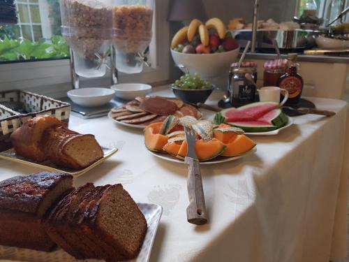 een tafel met borden brood en fruit erop bij Hostellerie De Bretonnière - Groupe Logis Hotels in Beaune
