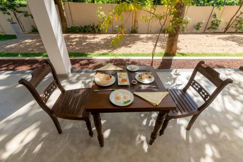 a table with plates of food sitting on it at Coastal Villa Mirissa in Mirissa