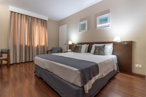 a hotel room with a large bed and a window at Gran Villagio Hotel SP by Castelo Itaipava in Sao Paulo