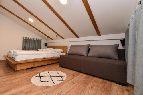ein Wohnzimmer mit einem Sofa und einem Bett in der Unterkunft Banja na Drini - Lux vikendice na obali reke in Banja Koviljača